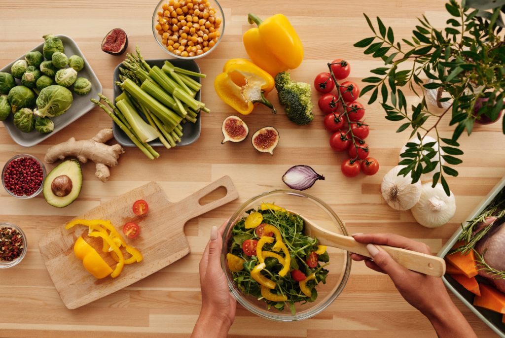 stół z warzywami, owocami i sałatami oraz miską